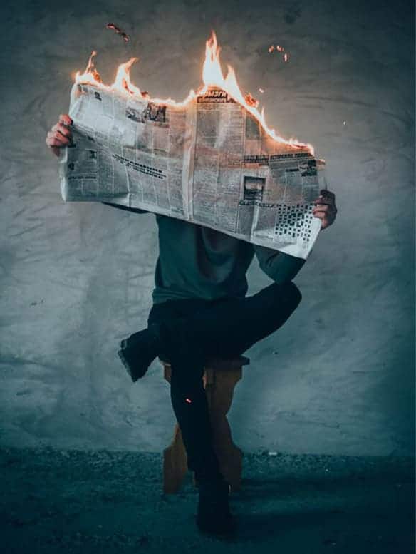 Un magicien Grenoble effectue un tour de magie avec un journal qui prend feu