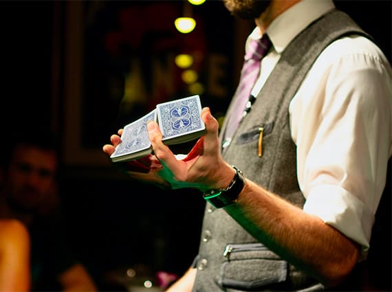 Un magicien coupe le paquet de cartes d'une main lors d'un team building magie